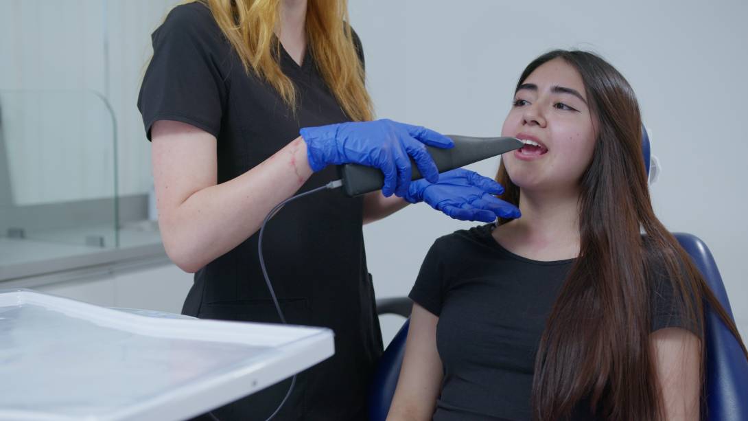 Una sesión con una paciente que es sometida a la medición que realiza el escáner intraoral de Wizz.